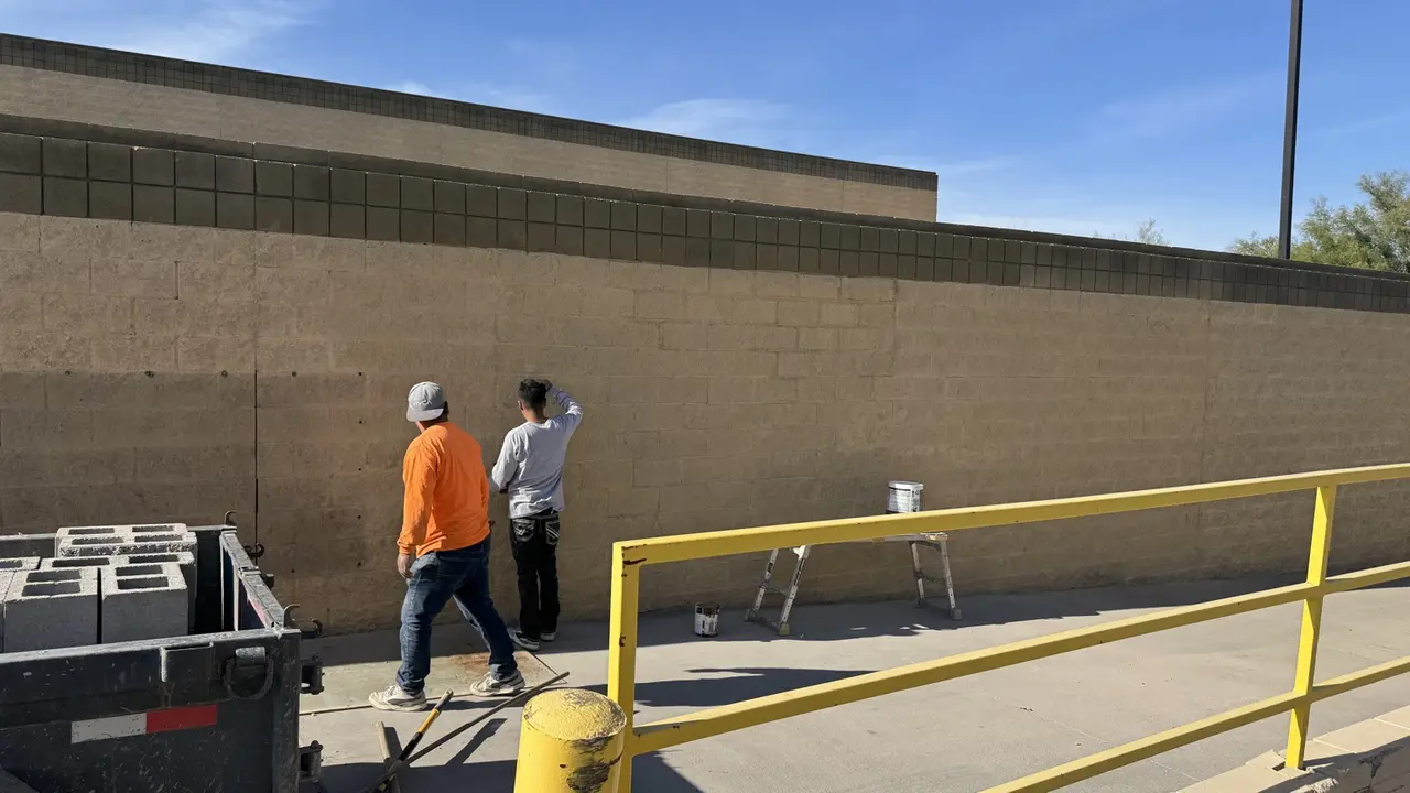 Surface finishing on the same reconstructed commercial CMU wall in Peoria Arizona