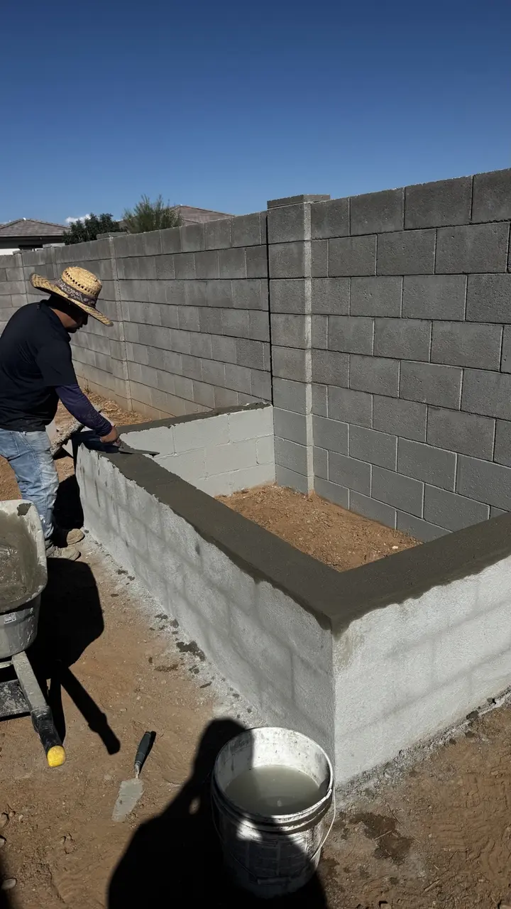 Fresh masonry cap being hand finished on a residential CMU planter