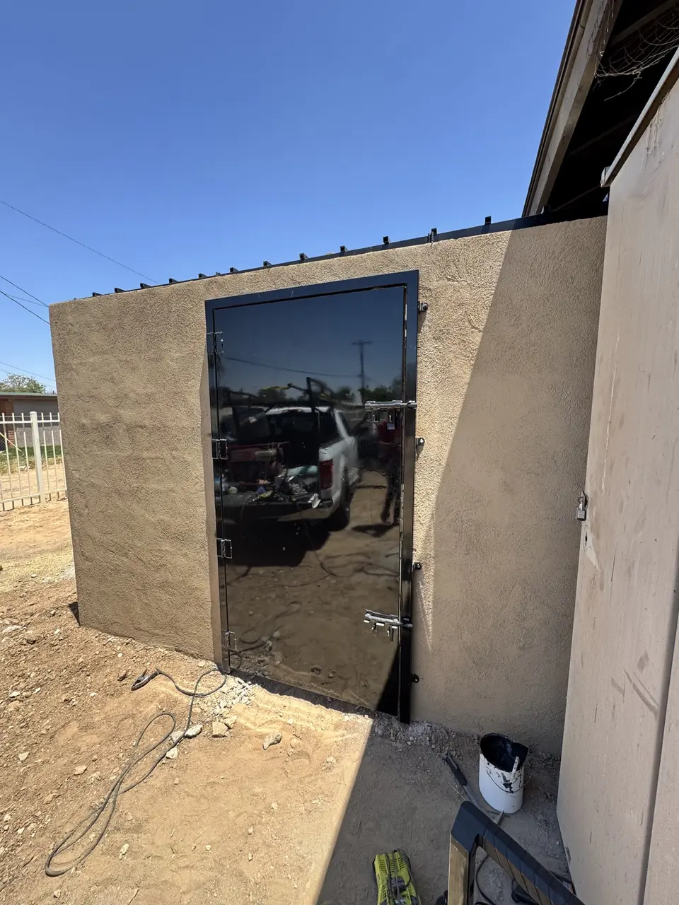 Completed stucco CMU enclosure with steel access gate in Phoenix Arizona